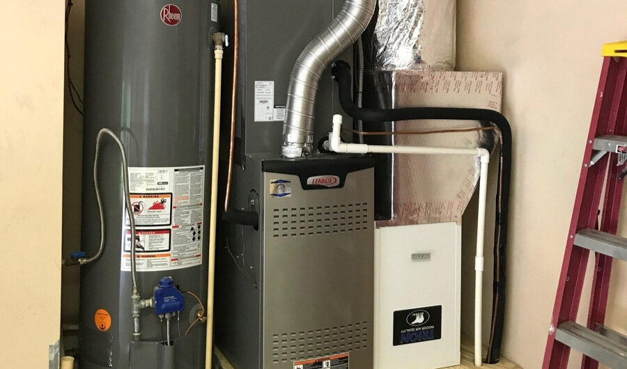 Technician servicing a residential gas water heater in a utility room